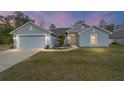 Charming one-story home with a well-manicured lawn, two car garage, and light blue painted siding at 15065 Se 93Rd Ave, Summerfield, FL 34491