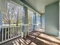 Covered front porch with brick flooring, white railings, and columns at 163 Crepe Myrtle Dr, Groveland, FL 34736