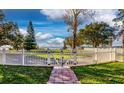 Landscaped backyard with a walkway and white fence, offering a tranquil lakeside view at 1735 Lakeshore Dr, Mount Dora, FL 32757