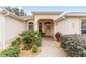 Welcoming front entry with arched entryway, landscaped walkway, and a bench at 1870 Saybrook Way, The Villages, FL 32162