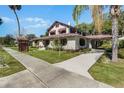 Charming stucco home featuring unique architectural details, a carport, and lush landscaping at 211 Cassady St, Umatilla, FL 32784