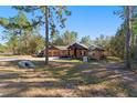 Landscaped yard with a one-story home and a long driveway at 2187 County Road 243C, Wildwood, FL 34785