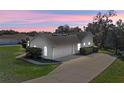 Rear view of house showcasing garage and landscaping at 23720 Sundance Dr, Sorrento, FL 32776