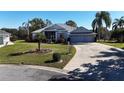 Single-story home with a two-car garage and manicured lawn at 24308 Belle Mede Dr, Leesburg, FL 34748