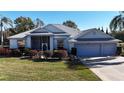 Single-story house with two-car garage and mature landscaping at 24308 Belle Mede Dr, Leesburg, FL 34748