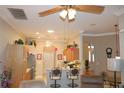 Open kitchen with wood cabinets, a breakfast bar, pendant lights, and a view of the living area at 24308 Belle Mede Dr, Leesburg, FL 34748