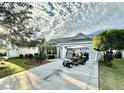 Home exterior with golf cart and palm tree accents in the driveway at 2458 Dunkirk Trl, The Villages, FL 32162