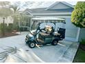 Green golf cart parked in front of a home at 2458 Dunkirk Trl, The Villages, FL 32162