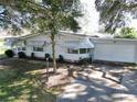 White single story home with attached garage, and landscaped yard at 25143 Barrow Hl, Leesburg, FL 34748