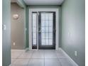 Front entry with dark door, light tile floors and sage green walls at 307 Batesburg Way, The Villages, FL 32162