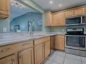 Kitchen boasts stainless steel appliances and light wood cabinets at 307 Batesburg Way, The Villages, FL 32162