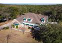 Lovely home nestled in a wooded area features a stone facade and a welcoming porch at 37008 Shalimar Dr, Fruitland Park, FL 34731