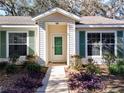 Front entrance with green door and landscaping at 3716 Plantation Blvd, Leesburg, FL 34748