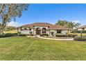 One-story house with walkway, lush landscaping, and a paved driveway at 39335 Harbor Hills Blvd, Lady Lake, FL 32159