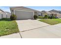 Gray house with driveway, landscaping, and a view of neighboring houses at 417 Pinecrest Loop, Davenport, FL 33837