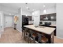 Modern kitchen with an island, dark cabinets, and stainless steel appliances at 417 Pinecrest Loop, Davenport, FL 33837