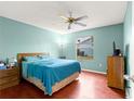 Blue bedroom with wood floors, a queen bed, and ceiling fan at 453 Hildalgo Dr, Lady Lake, FL 32159