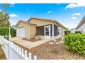 Tan house with screened porch, white picket fence, and a gravel pathway at 453 Hildalgo Dr, Lady Lake, FL 32159