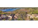 Aerial view of a single-Gathering home located near a lake and golf course with mature trees at 4822 Sawgrass Lake Cir, Leesburg, FL 34748