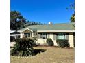 Cute yellow single story home with green roof and palm tree at 505 W 10Th Ave, Mount Dora, FL 32757