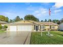 Single story house with a two-car garage and American flag at 6525 Borg St, Leesburg, FL 34748