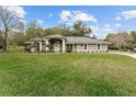 House exterior showcasing a well-maintained lawn and gray siding at 7237 Edmund Ct, Mount Dora, FL 32757