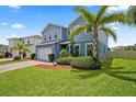 Two-story house with gray siding, landscaping, and a paved driveway at 810 Maplebrook Loop, Apopka, FL 32703