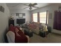 Cozy living room featuring a sofa and flat-screen TV at 11221 Lake Eustis Dr, Leesburg, FL 34788