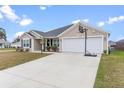 Beige house with a two-car garage and basketball hoop at 11272 Stewart Loop, Oxford, FL 34484