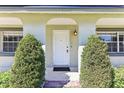 Charming front entrance with a classic white door flanked by manicured shrubs at 118 Shomate Dr, Longwood, FL 32750