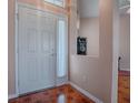 Front entry with tiled floor, white door and a half wall at 12060 Se 176Th Loop, Summerfield, FL 34491