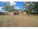 Single-story house with a landscaped yard and large oak trees at 13588 Sw 105Th Pl, Dunnellon, FL 34432