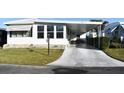 Front view of a white manufactured home with a carport and landscaping at 1401 W Highway 50 # 89, Clermont, FL 34711