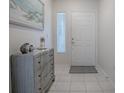 Bright entryway with a gray dresser, artwork, and tiled floor at 14267 Se 85Th Ter, Summerfield, FL 34491