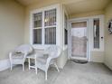 Front porch with white wicker chairs and a small table at 14267 Se 85Th Ter, Summerfield, FL 34491