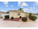 Tan house with manicured landscaping and a walkway at 1521 Trenton Ln, The Villages, FL 32162