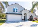 Two-story house with a gray exterior, white garage door, and landscaping at 17120 Cypresswood Way, Clermont, FL 34714