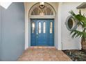 Inviting entryway with a stylish blue door and arched window detail at 17640 Las Brisas Ct, Winter Garden, FL 34787