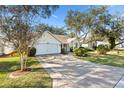 Cute yellow house with a 2-car garage and nicely landscaped lawn at 208 Desota Ct, The Villages, FL 32159