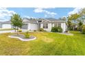 Single-story home with a landscaped yard and a screened-in garage at 2123 Barbosa Ct, The Villages, FL 32159