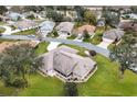 Aerial view of a home with mature trees, landscaping, and a view of surrounding homes and a lake at 21721 Loch Haven Pass, Leesburg, FL 34748