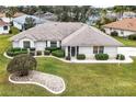 An eye-level aerial view of a home with a manicured front lawn and tastefully trimmed shrubbery at 21721 Loch Haven Pass, Leesburg, FL 34748
