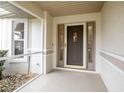 Front entry with glass sidelights and storm door at 21721 Loch Haven Pass, Leesburg, FL 34748