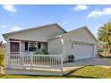 Front view of a house with white fence and double garage at 2214 Quinn Ln, The Villages, FL 32162