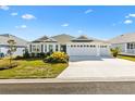 Two-story home with white exterior, gray roof and landscaping at 2484 Lynette Ave, The Villages, FL 32163