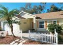 House exterior with a white picket fence, palm tree, and stone walkway at 25107 Meriweather Rd, Leesburg, FL 34748