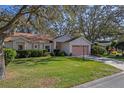 House exterior showcasing a pink garage and neatly trimmed shrubs at 25236 River Crest Dr, Leesburg, FL 34748