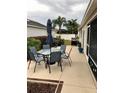 Outdoor patio area with table, chairs, and umbrella at 2552 Mariel Way, The Villages, FL 32162