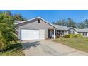 Gray siding, attached garage, and lush green lawn at 26154 Newcombe Cir, Leesburg, FL 34748