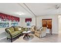 Bright living room with two armchairs, a sofa, and a wooden cabinet at 2753 Vindale Rd, Tavares, FL 32778